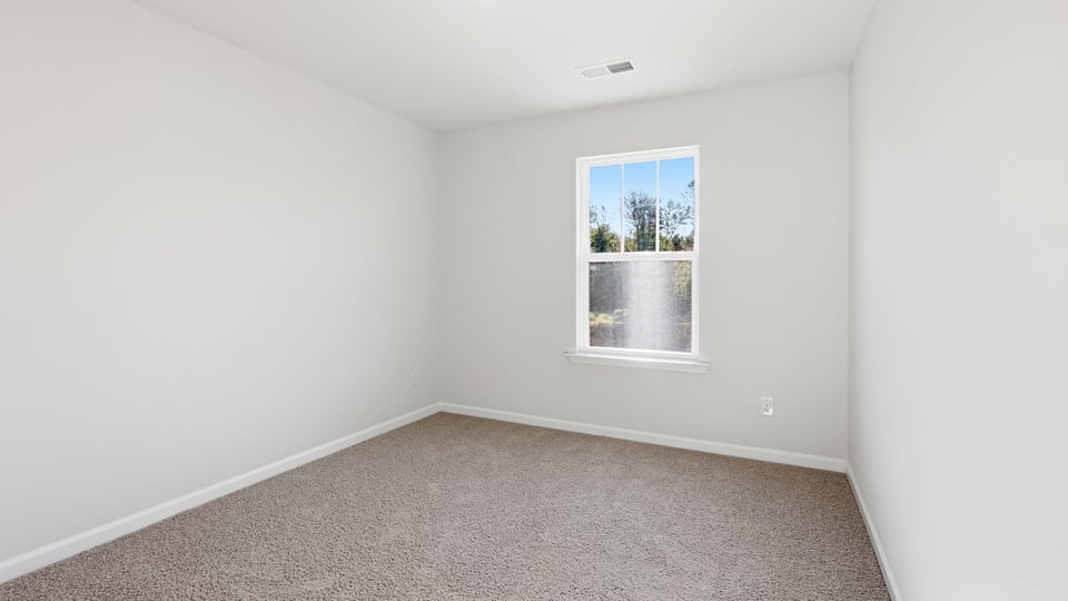 Bedroom with carpet and window.