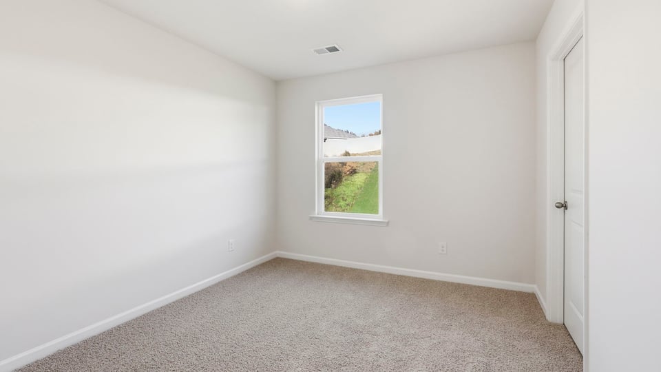 Bedroom with carpet and window.