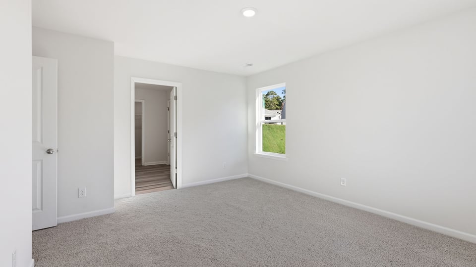 Bedroom with carpet and window.