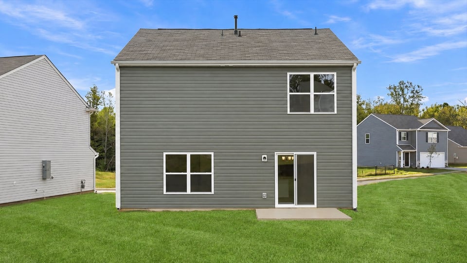 Back exterior of home with large backyard.