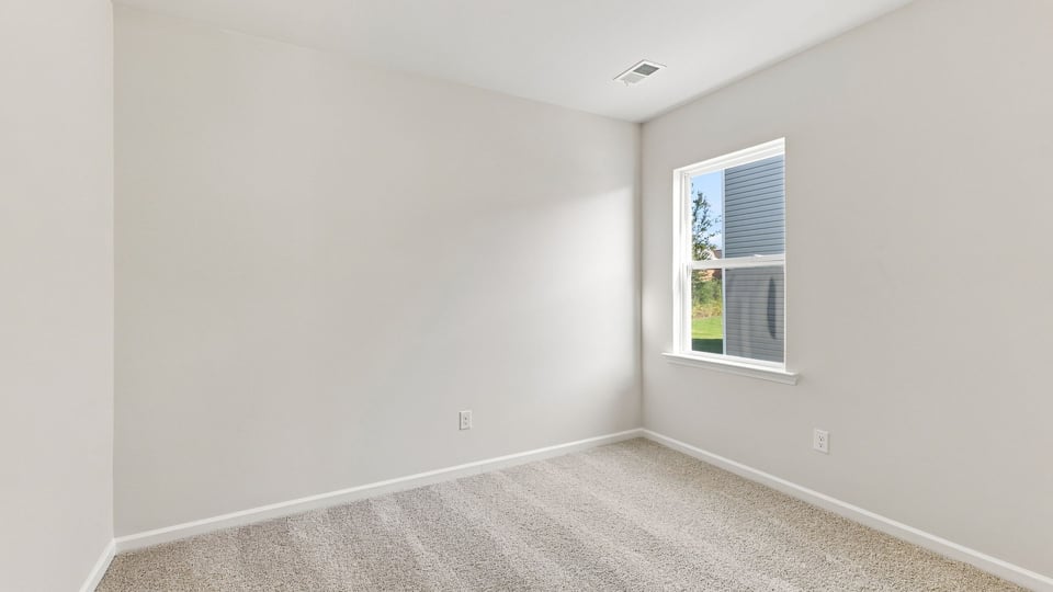 Bedroom with carpet and window.