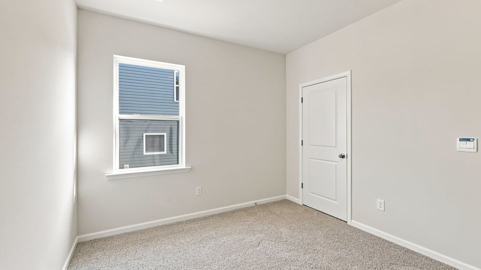 Bedroom with carpet and window.