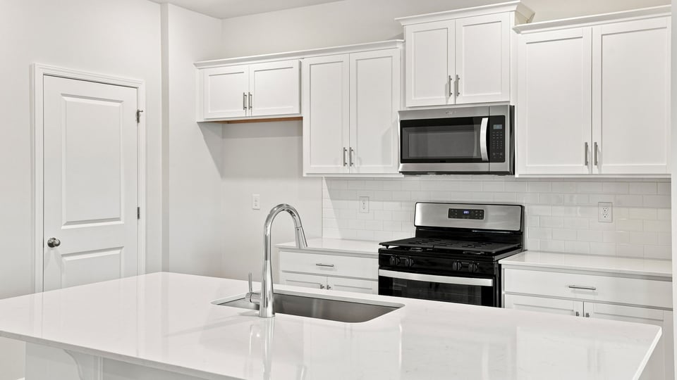 Kitchen and island with quartz countertops.