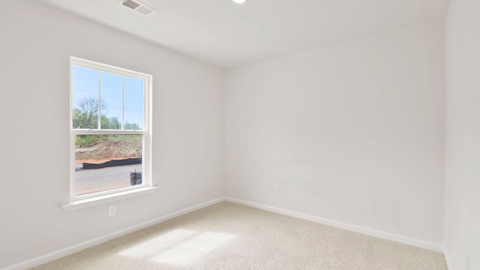 Bedroom with carpet and window.