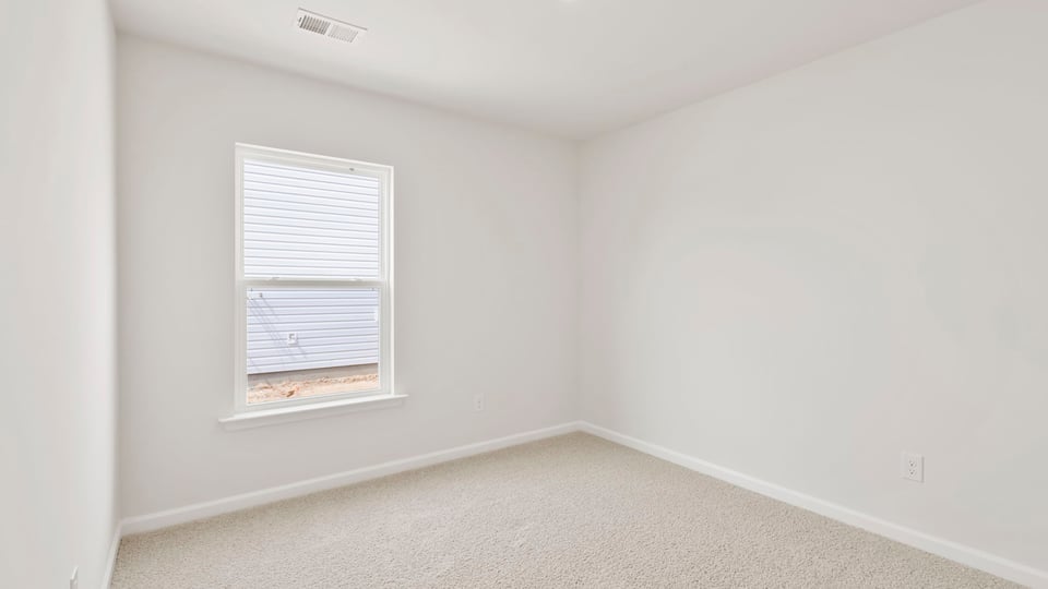 Bedroom with carpet and window.