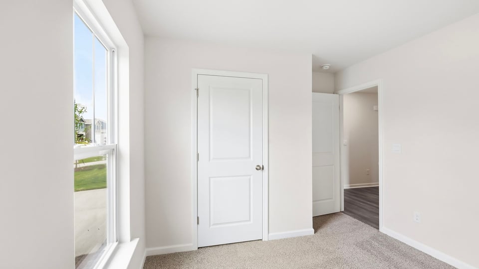 Bedroom with window and carpet.