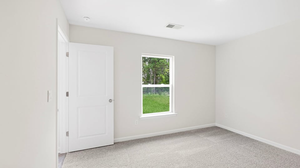 Bedroom with carpet and windows.