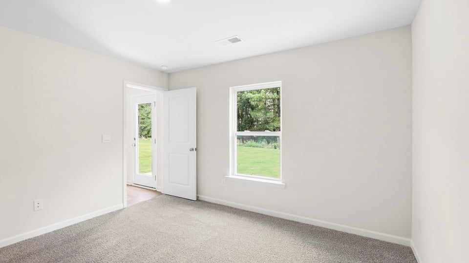 Bedroom with carpet and windows.