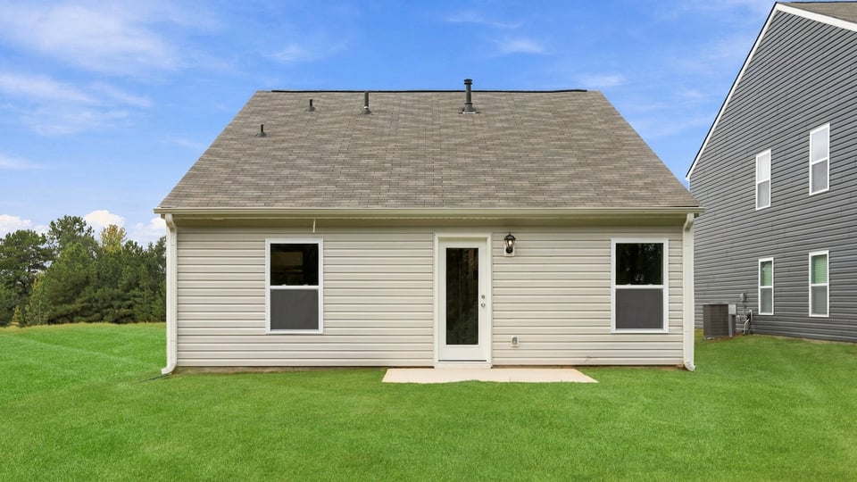 Back exterior of home with large backyard.
