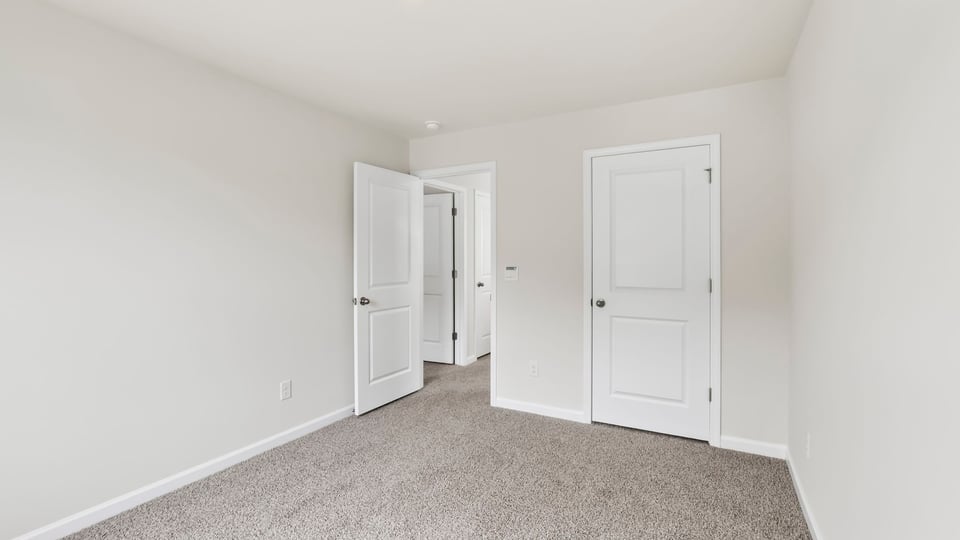 Bedroom with carpet and windows.