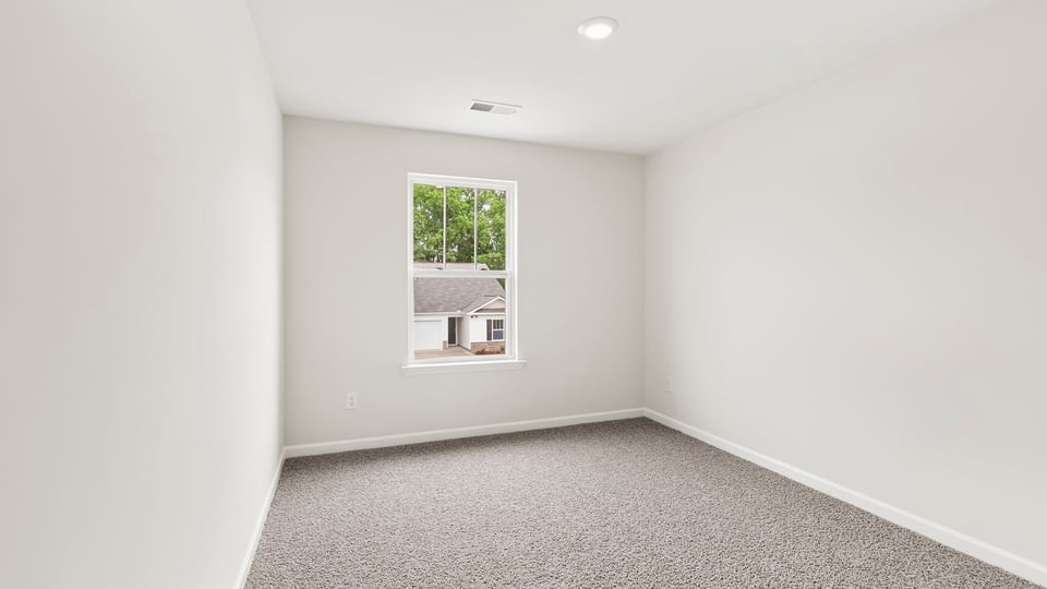 Bedroom with carpet and windows.