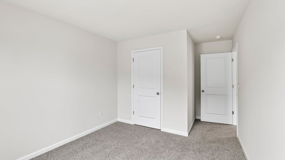 Bedroom with carpet and windows.