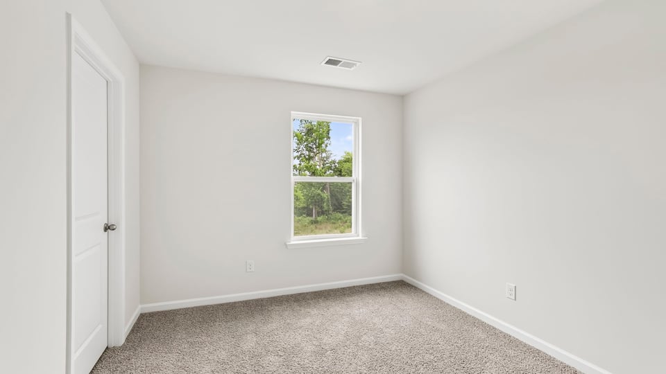 Bedroom with carpet and windows.