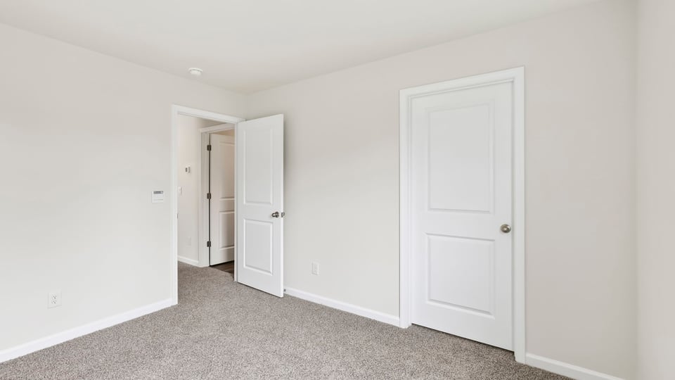Bedroom with carpet and windows.
