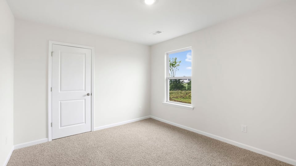 Bedroom with carpet and window.