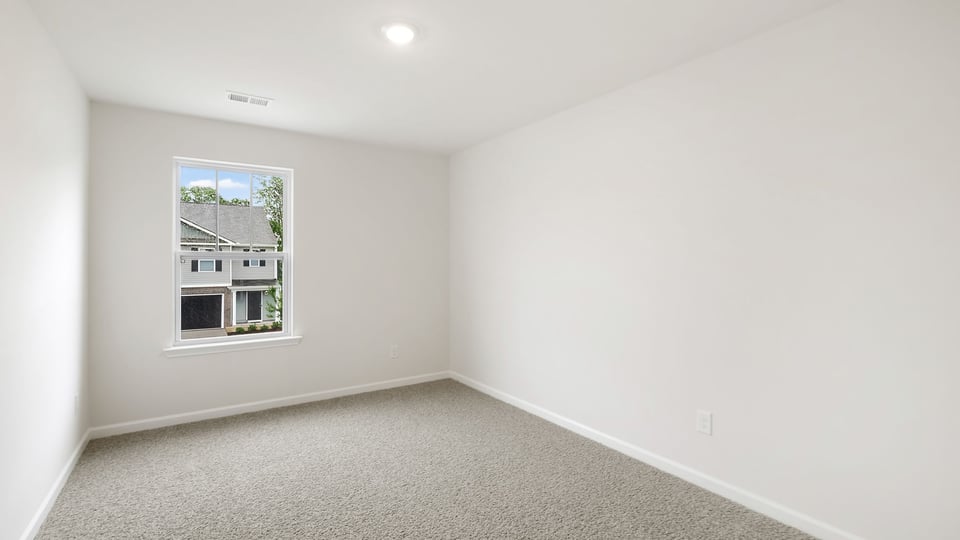 Bedroom with carpet and window.