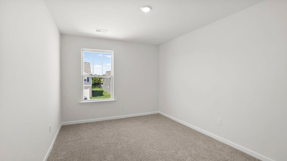 Bedroom with carpet and window.