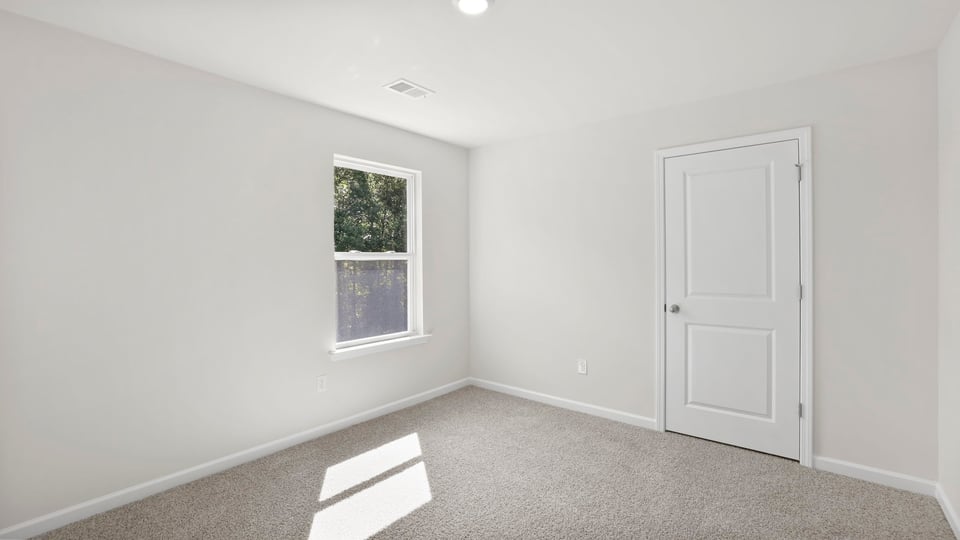 Bedroom with carpet and window.
