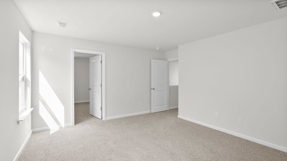 Bedroom with carpet and window.