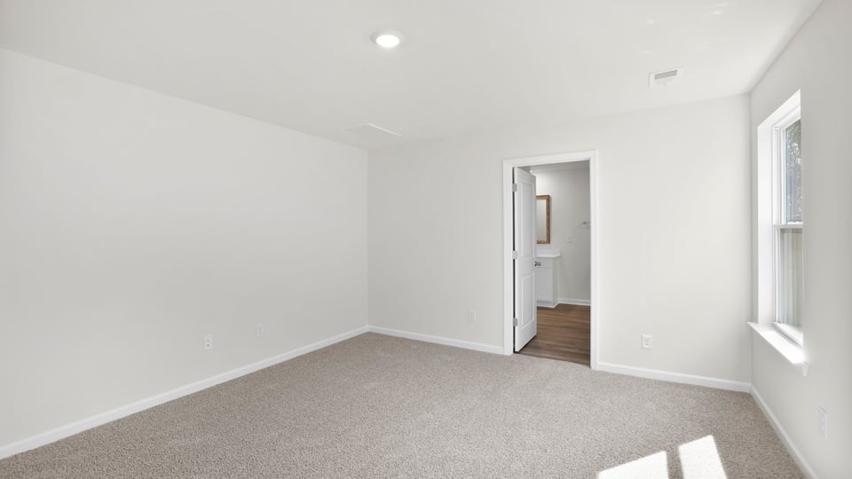 Bedroom with carpet and window.