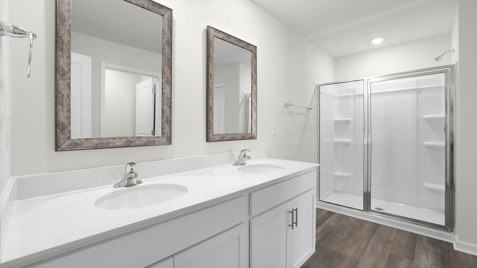 Bathroom with double vanity sink and walk in shower.