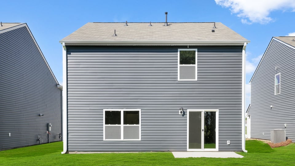 Back exterior of home with large backyard.
