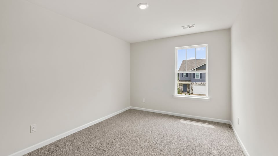 Bedroom with carpet and windows.