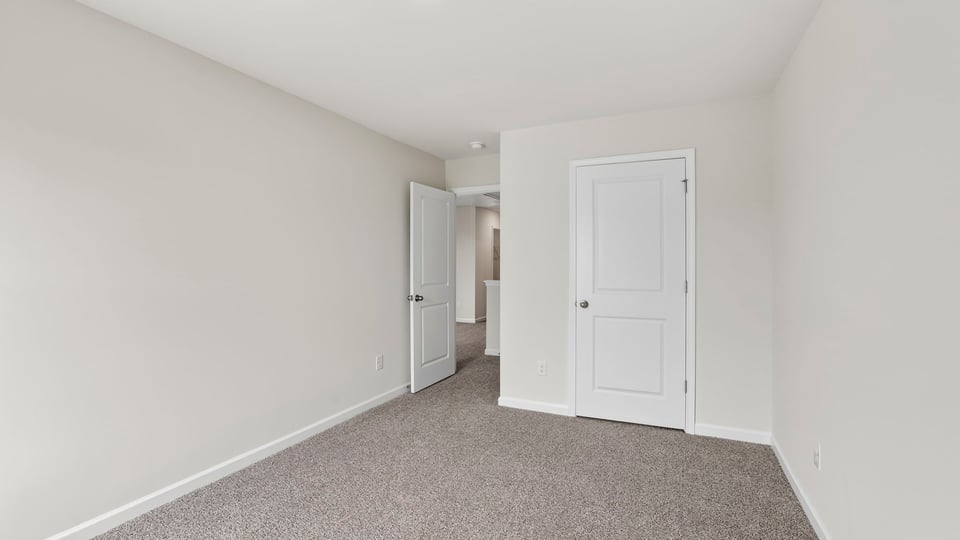 Bedroom with carpet and windows.