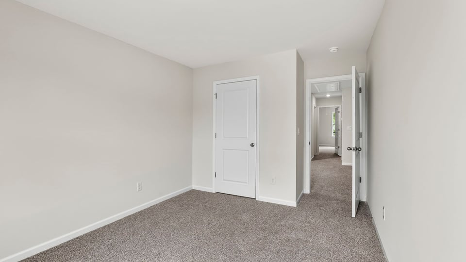 Bedroom with carpet and windows.