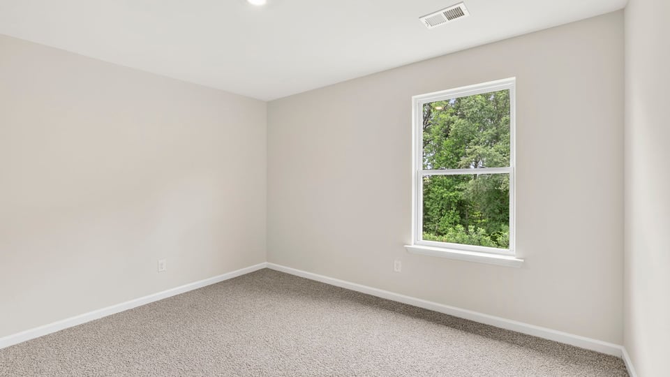Bedroom with carpet and windows.