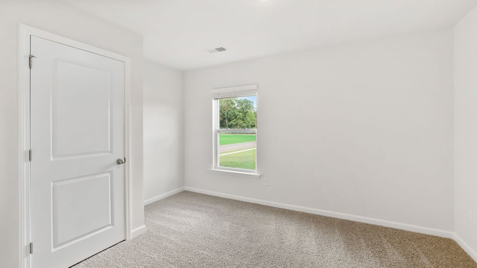 Bedroom with carpet and windows.