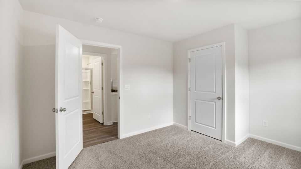 Bedroom with carpet and windows.
