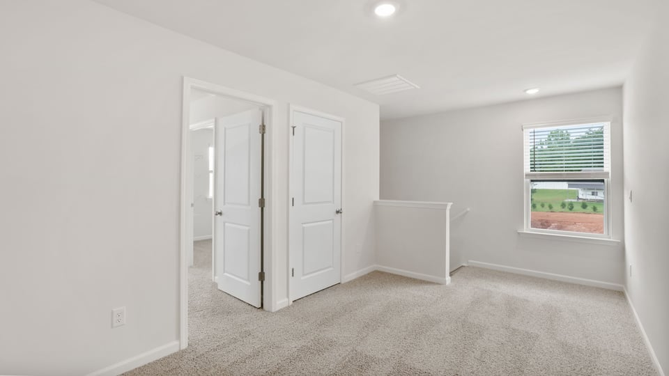 Bedroom with carpet and windows.