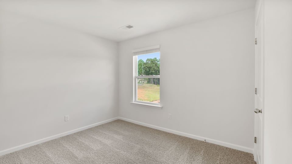Bedroom with carpet and windows.