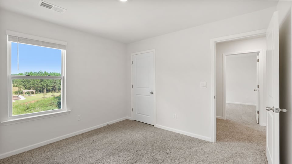 Bedroom with carpet and windows.