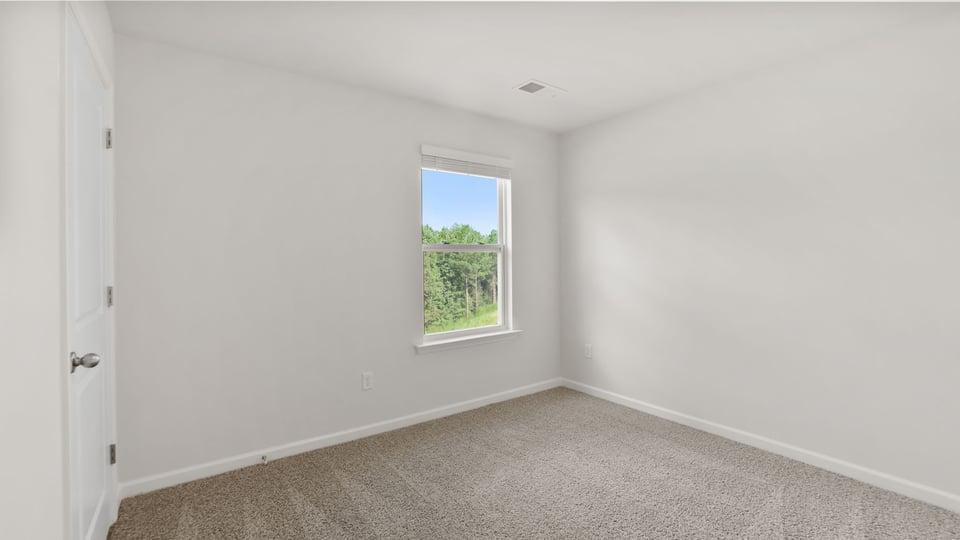 Bedroom with carpet and windows.