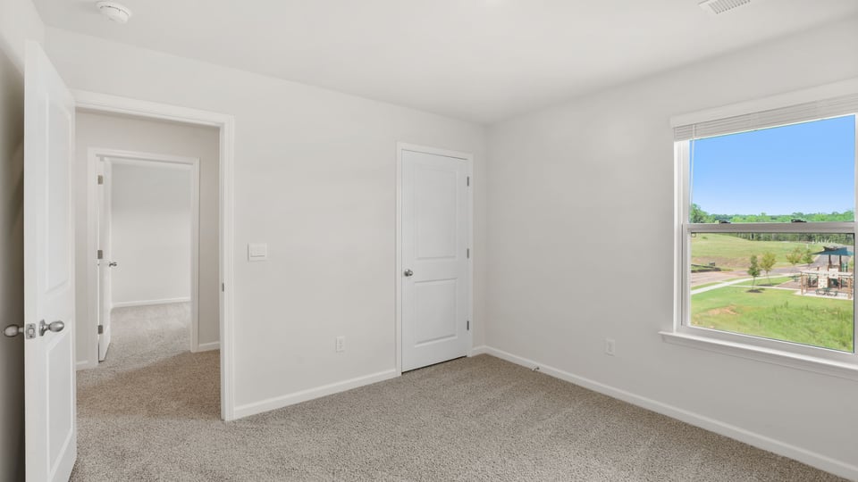 Bedroom with carpet and windows.
