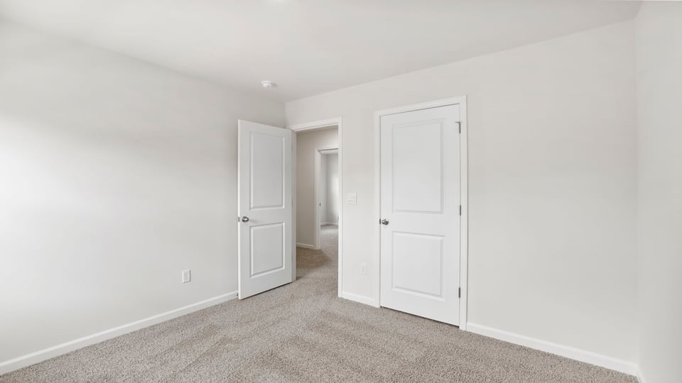 Bedroom with carpet and windows.