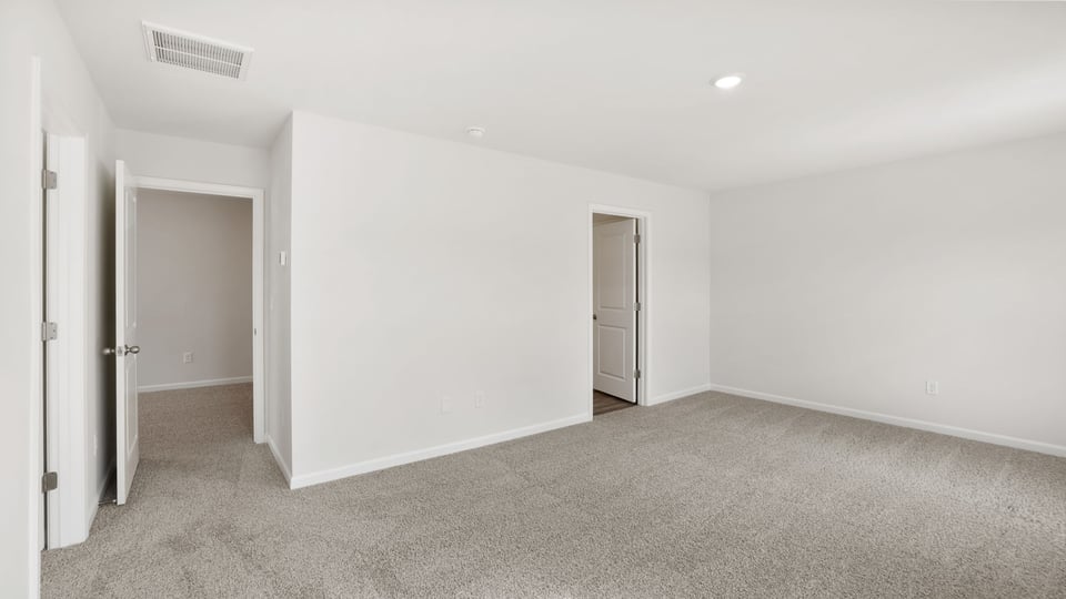 Bedroom with carpet and windows.