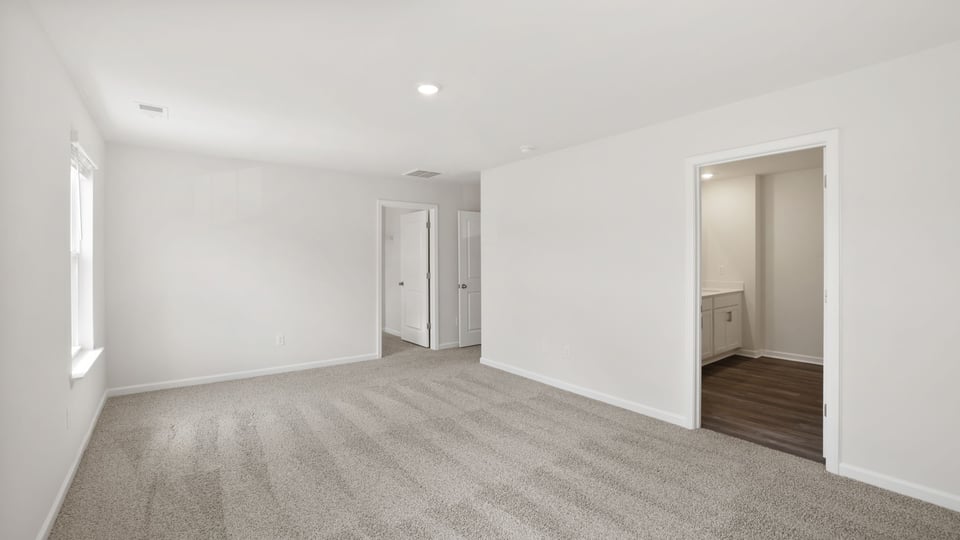 Bedroom with carpet and windows.
