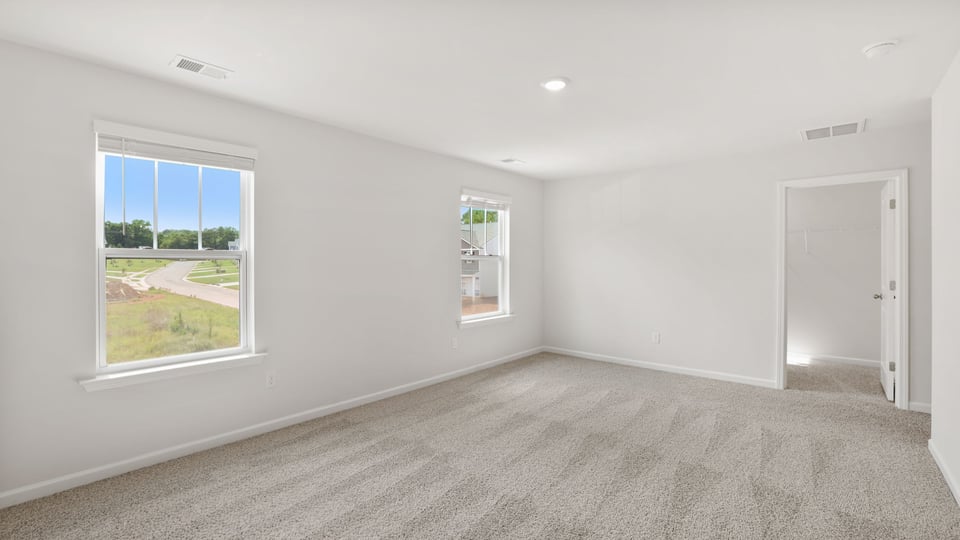 Bedroom with carpet and windows.