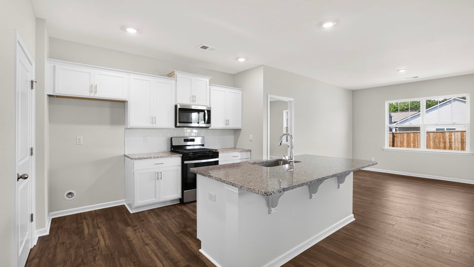 Kitchen and island with stainless steel appliances.
