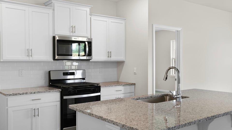Kitchen and island with stainless steel appliances.