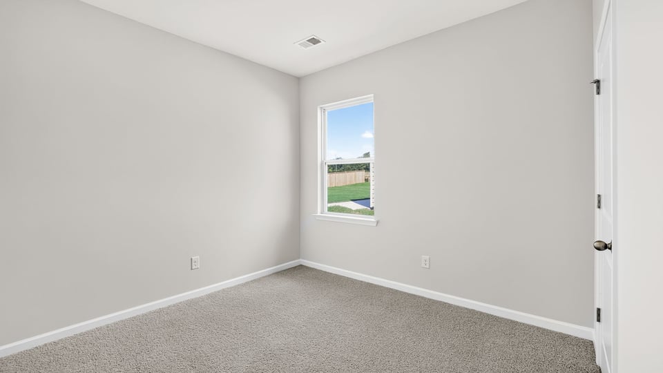 Bedroom with carpet and window.