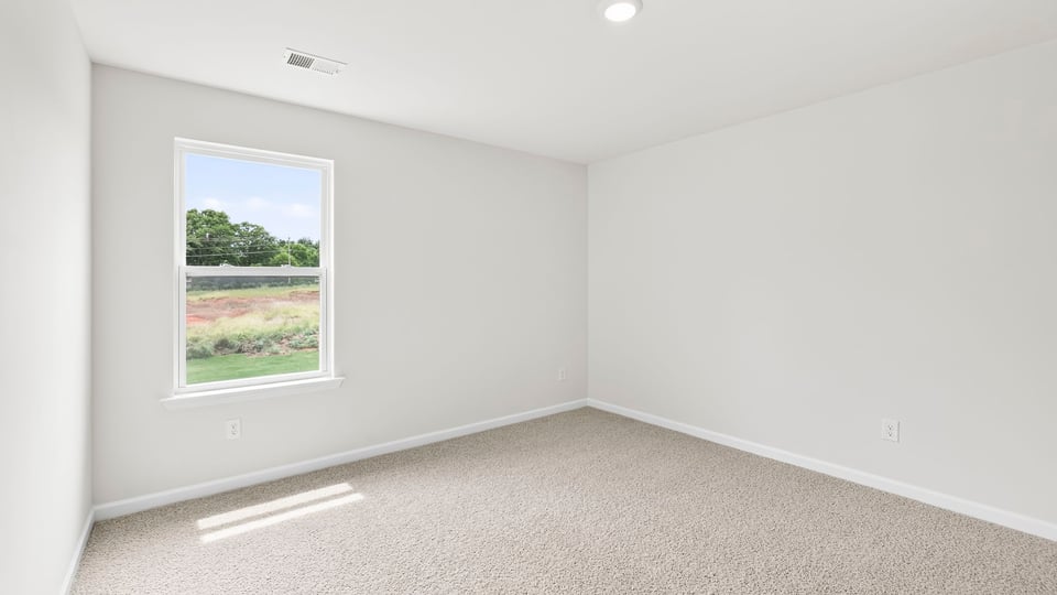 Bedroom with carpet and windows.