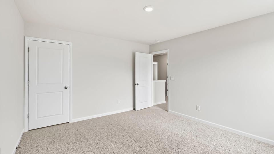 Bedroom with carpet and windows.