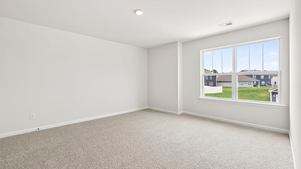 Bedroom with carpet and windows.