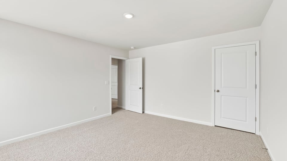Bedroom with carpet and windows.