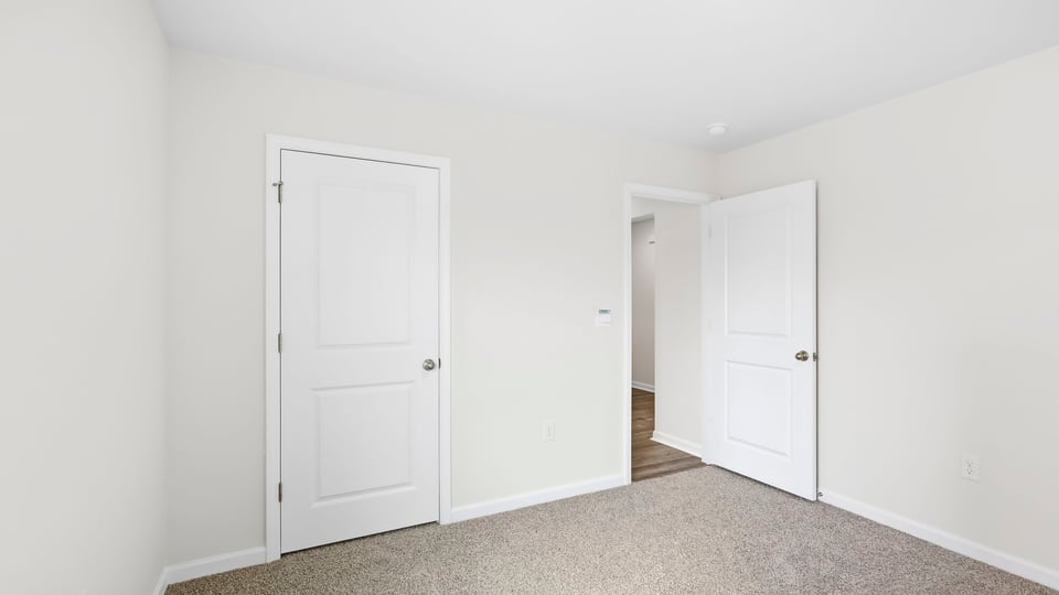 Bedroom with carpet and window.