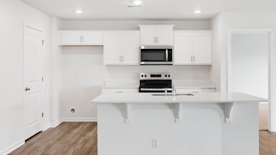 Kitchen and island with quartz countertops.